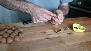 hands of a man cracking walnuts with a nutcracker video