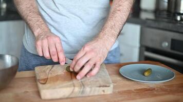 man slicing Salted pickles with knife from jar can, Cucumbers preservations, conservation. Salted pickled cucumbers in a wooden table. Preparing the salad video