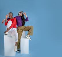 Two women pose on blue background with copy space banner photo