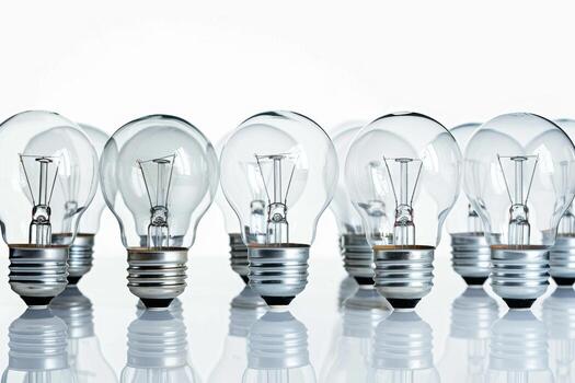 Transparent bulbs arranged in a row on a reflective surface photo