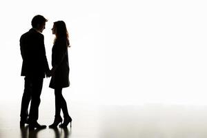 Couple holding hands in silhouette on light background photo