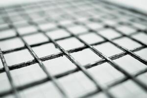Close-up of the surface of a metal grating with square holes photo