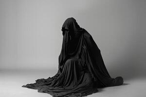 A mysterious figure draped in black cloth photo