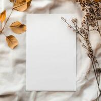 Blank paper with dried flowers on soft fabric background, perfect for invitations or decorative notes in natural light photo