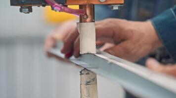 Worker uses an old hand-held welding machine to weld a metal component. Close up. Slow motion video