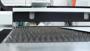 An automated laser machine functions in a pristine, aesthetically pleasing, and meticulously organized production environment. Medium shot. Slow motion video