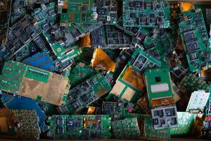 pile of electronic waste on factory floor is circuit board of mobile phone waiting to be processed extract gold to separate precious metal from electronic waste. extracting precious metal from e-waste photo