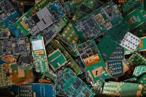 pile of electronic waste on factory floor is circuit board of mobile phone waiting to be processed extract gold to separate precious metal from electronic waste. extracting precious metal from e-waste photo
