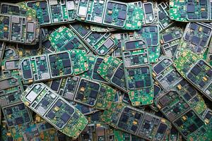 pile of electronic waste on factory floor is circuit board of mobile phone waiting to be processed extract gold to separate precious metal from electronic waste. extracting precious metal from e-waste photo