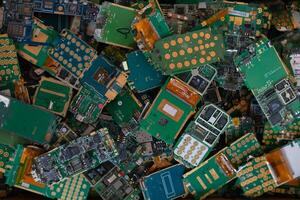 pile of electronic waste on factory floor is circuit board of mobile phone waiting to be processed extract gold to separate precious metal from electronic waste. extracting precious metal from e-waste photo