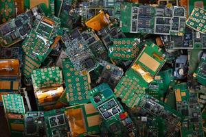 pile of electronic waste on factory floor is circuit board of mobile phone waiting to be processed extract gold to separate precious metal from electronic waste. extracting precious metal from e-waste photo