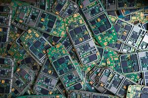 pile of electronic waste on factory floor is circuit board of mobile phone waiting to be processed extract gold to separate precious metal from electronic waste. extracting precious metal from e-waste photo