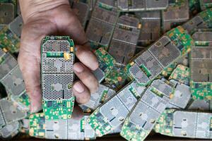 pile of electronic waste on factory floor is circuit board of mobile phone waiting to be processed extract gold to separate precious metal from electronic waste. extracting precious metal from e-waste photo