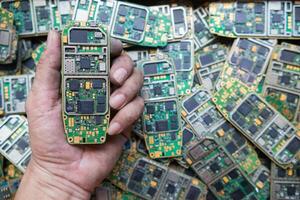 pile of electronic waste on factory floor is circuit board of mobile phone waiting to be processed extract gold to separate precious metal from electronic waste. extracting precious metal from e-waste photo