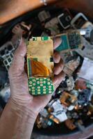 pile of electronic waste on factory floor is circuit board of mobile phone waiting to be processed extract gold to separate precious metal from electronic waste. extracting precious metal from e-waste photo