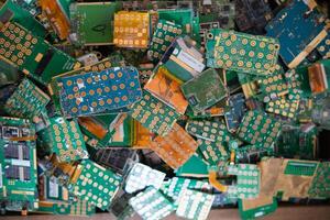 pile of electronic waste on factory floor is circuit board of mobile phone waiting to be processed extract gold to separate precious metal from electronic waste. extracting precious metal from e-waste photo