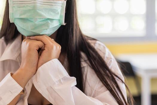 Female doctor in quarantine room control coronavirus covid-19 are praying to God requesting that the coronavirus covid-19 not spread beyond control. The doctor is praying to God with faith and hope. photo