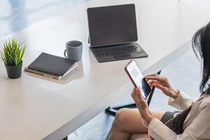 businesswoman is using a smartphone to communicate and check work from home online because she is starting a business that can order and check from anywhere online.online business ideas photo