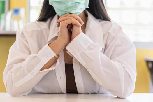 Female doctor in quarantine room control coronavirus covid-19 are praying to God requesting that the coronavirus covid-19 not spread beyond control. The doctor is praying to God with faith and hope. photo