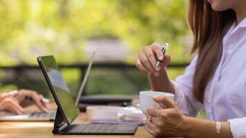 young businesswoman is reviewing results of corporate network via laptops and the Internet in order to prepare documents for meetings to give investors confidence in doing business. photo