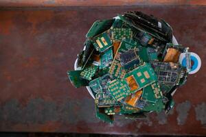 pile of electronic waste on factory floor is circuit board of mobile phone waiting to be processed extract gold to separate precious metal from electronic waste. extracting precious metal from e-waste photo