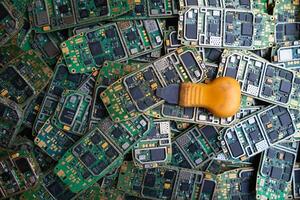 pile of electronic waste on factory floor is circuit board of mobile phone waiting to be processed extract gold to separate precious metal from electronic waste. extracting precious metal from e-waste photo