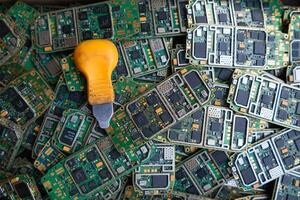 pile of electronic waste on factory floor is circuit board of mobile phone waiting to be processed extract gold to separate precious metal from electronic waste. extracting precious metal from e-waste photo