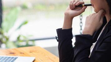 young businesswoman is reviewing results of corporate network via laptops and the Internet in order to prepare documents for meetings to give investors confidence in doing business. photo