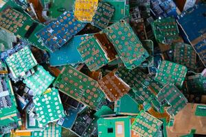 pile of electronic waste on factory floor is circuit board of mobile phone waiting to be processed extract gold to separate precious metal from electronic waste. extracting precious metal from e-waste photo