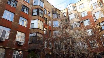 Red old house. Stock footage. Residential building with different windows with a sunny house and broken gray trees. video