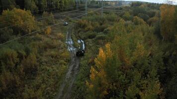 ATVs driving on muddy road in forest. Clip. Top view of off-road quad bikes after rain in forest. ATVs are walking on muddy road in forest in autumn video