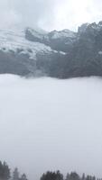 Fly over majestic mountain peaks and a fog. Creative. Valley covered by clouds and mountains on the background. video