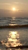 Close-up of small waves on background of sunset. Creative. Rolling small waves on seashore with sunset horizon. Waves on background of sea sunset video