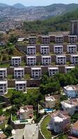 Top view of tourist town with hotels and swimming pools. Clip. Resort town with cottages on hills on summer day. Summer resort town on mountainside video