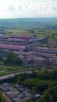 Top view of small factory town by river. Clip. Beautiful landscape with highway and river near town with factory in wooded area. Factory town by river with bridge in forest area in summer video