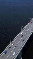 Bird's-eye view. Clip. A huge bridge over the ocean for the movement of cars in different directions and boats and ships passing by are visible. video