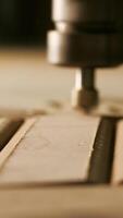Close-up of needle for drilling on wood. Creative. Machine for drilling patterns on wooden boards. Wood processing and carving with industrial machines video