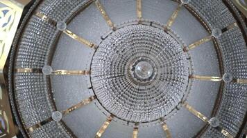 Crystal chandelier in temple. Scene. Beautiful light of crystal chandelier under dome of temple. Domed vault with chandelier and crystal ornaments in temple video