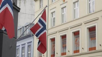 Travel to Norway. Action.Narrow street with two red flags of the country of Norway. video
