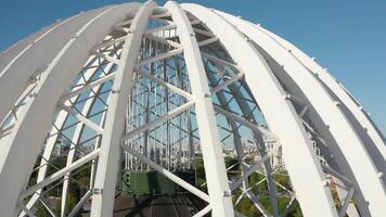 Top view of domed structure with beams. Stock footage. Beautiful architecture of metal dome with beams. Dome made of metal semi-arches with air space on background of modern city video