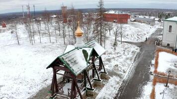 Drone view. Clip. Beautiful fresh grass covered with white first snow and large cultural temples with golden domes decorated in a special style. video