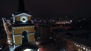 View of the night year from a helicopter. Clip. A dark city illuminated by street lamps with high houses and towers and a road with traffic is visible. video