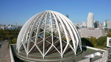 Aerial view of an unusual building with a spherical structure looking like a dome. Stock footage. Concept of architecture. video