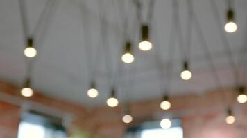Blurred view of modern design of ceiling lighting indoors. Stock footage. Background of hanging light bulbs. video