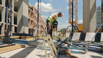 Construction Worker Using Power Tool on Site. A construction worker operates a power tool while working on an outdoor construction site. video