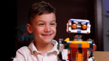 Happy boy smiling and playing with robotics at home photo