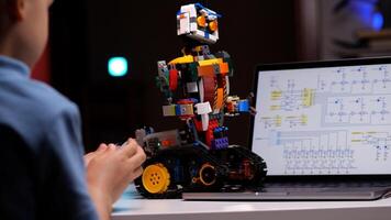 Child programming robot using laptop in high tech computer class photo