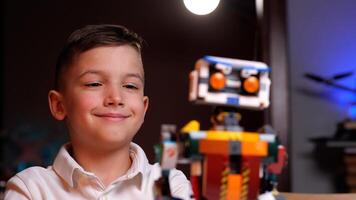 Happy child programming robot from building blocks at home photo