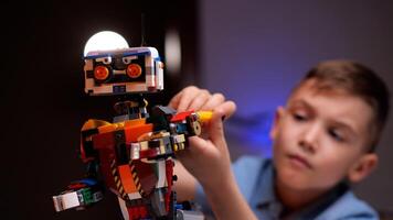 Young engineer assembling a robot from plastic bricks photo