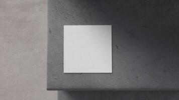 square white card on cracked concrete step seen from above with blurred background photo